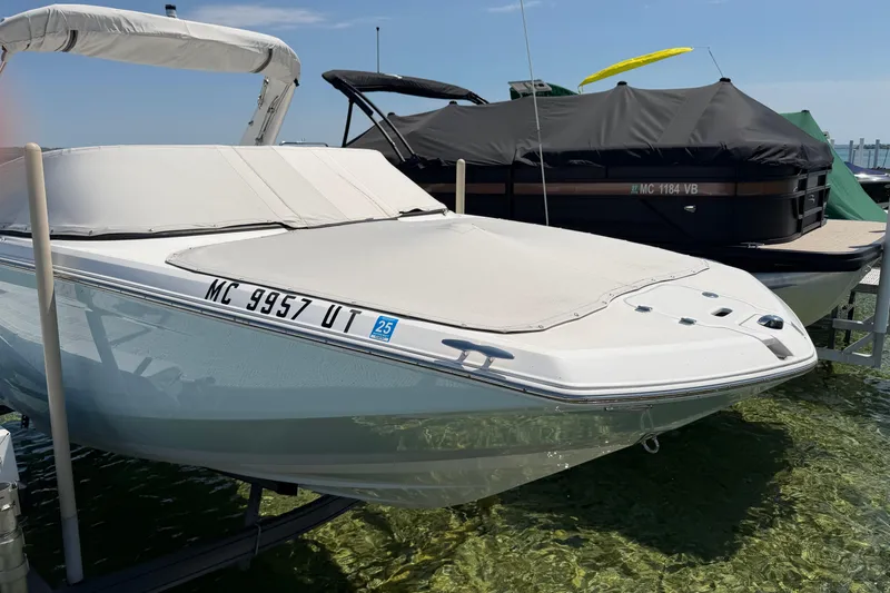 Slide: The Image of 2022 Regal 22 FasDeck boat docked with cover, clear water background. - 2