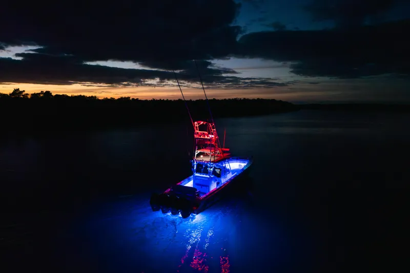 Slide: The Image of 2022 Nor-Tech 392 Super Fish boat illuminated at night on calm water. - 54