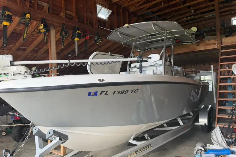Slide: The Image of 2022 Bluewater 2550 CC boat in garage, surrounded by tools and equipment. - 2