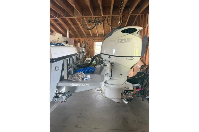 Slide: The Image of 2022 Bluewater 2550 CC boat with Suzuki outboard motor in a garage. - 6
