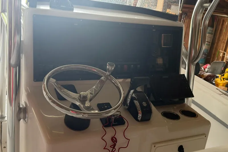 Slide: The Image of 2022 Bluewater 2550 CC boat console with steering wheel and controls. - 8