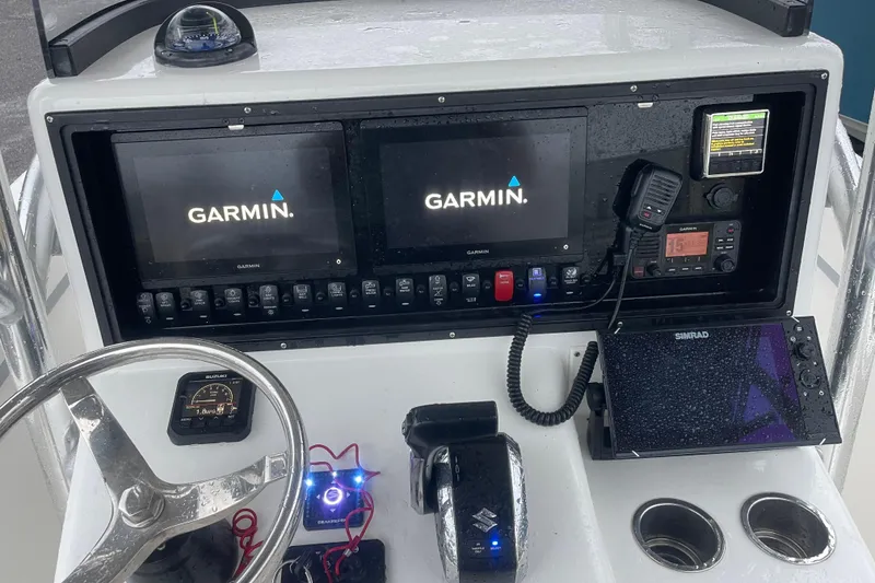 Slide: The Image of 2022 Bluewater 2550 CC boat dashboard with Garmin and Simrad navigation systems. - 9