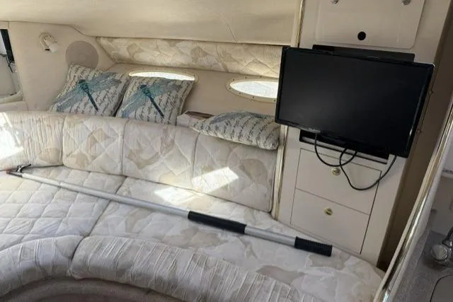 Slide: The Image of Interior of 1999 Sea Ray 290 Sundancer with cozy seating and mounted TV. - 16