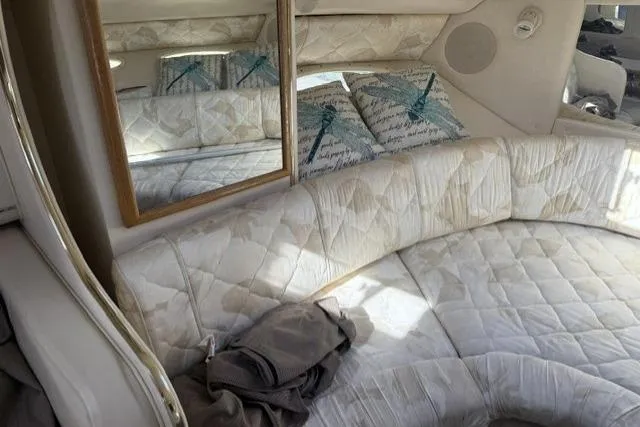 Slide: The Image of Interior of 1999 Sea Ray 290 Sundancer with quilted seating and decorative pillows. - 17