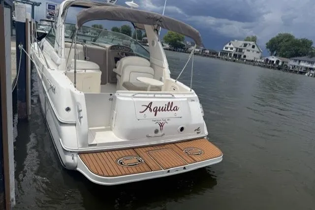 Slide: The Image of 1999 Sea Ray 290 Sundancer docked, featuring a spacious deck and elegant design. - 19