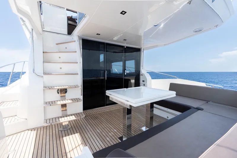 Slide: The Image of Luxurious 2017 Galeon 550 Fly yacht deck with seating, table, and ocean view. - 14