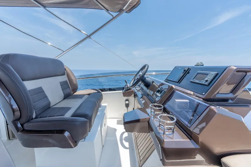 Slide: The Image of Flybridge helm of 2017 Galeon 550 Fly yacht with luxurious seating and navigation controls. - 23