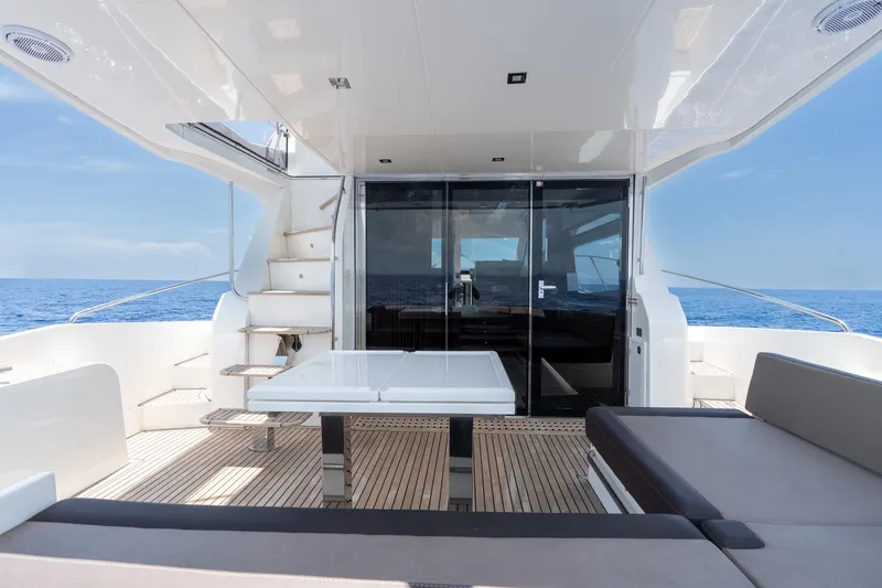 Slide: The Image of Luxurious 2017 Galeon 550 Fly yacht deck with seating, table, and ocean view. - 11