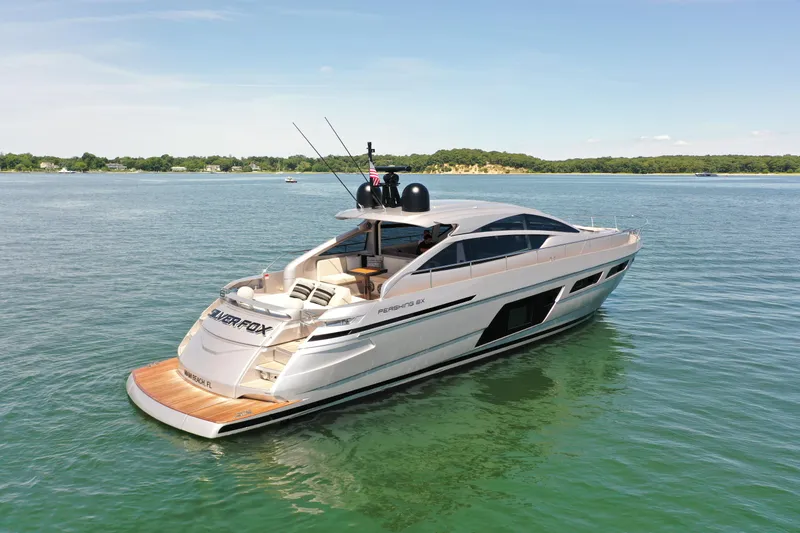 Slide: The Image of A luxurious Pershing 6X yacht on calm water, surrounded by green landscape. - 1
