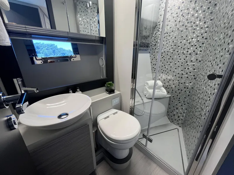 Slide: The Image of Modern yacht bathroom with a sink, toilet, and shower. - 15