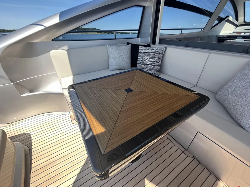 Slide: The Image of Luxurious seating area on a modern yacht with a wooden table and cushions. - 32