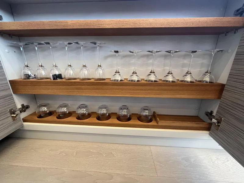 Slide: The Image of A cabinet with wine glasses and tumblers on wooden shelves. - 33