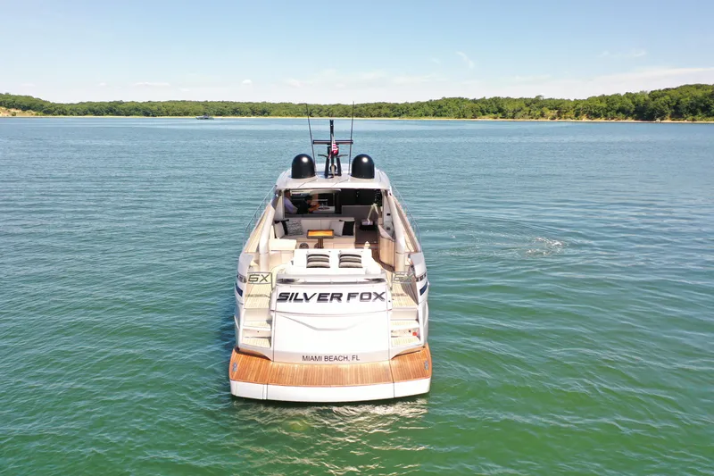 Slide: The Image of A luxury yacht on calm water with a wooded shoreline in the background. - 4