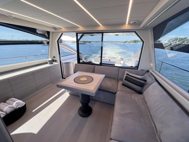 Slide: The Image of Interior of a modern yacht with gray sofas and a table, overlooking the water. - 5