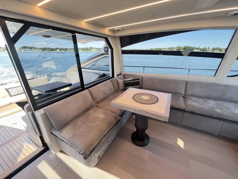 Slide: The Image of Interior of a luxury yacht with gray sofas and a table, overlooking the water. - 6