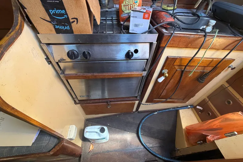 Slide: The Image of Interior of a 1991 Hylan Offshore Steel Cutter with stove and wooden cabinetry. - 15