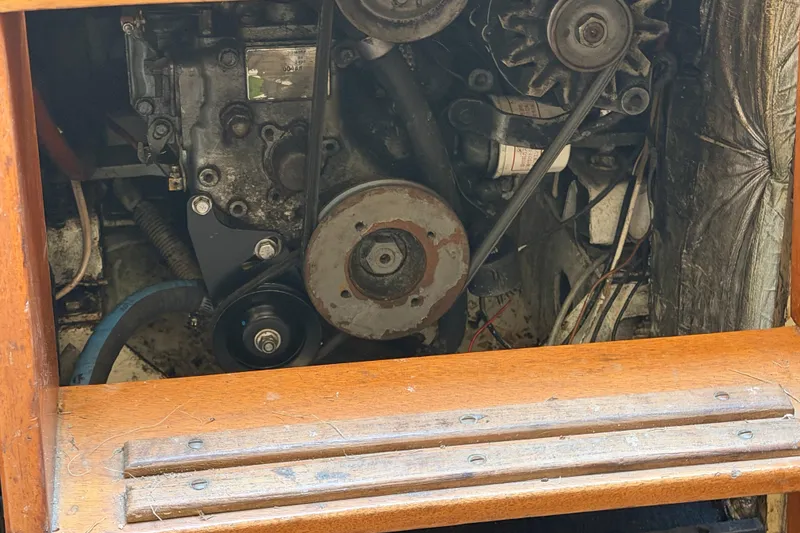 Slide: The Image of Engine compartment of a 1991 Hylan Offshore Steel Cutter sailboat, showcasing mechanical components. - 18