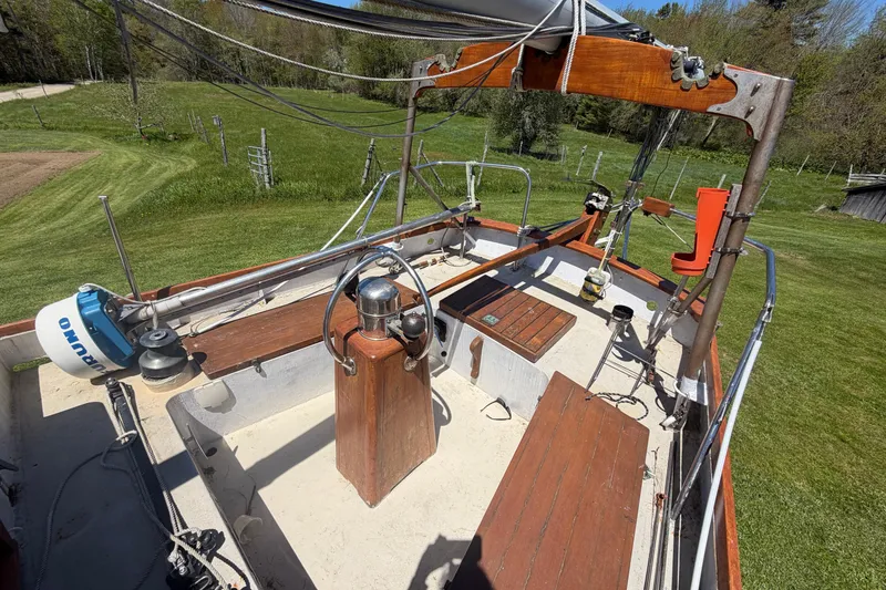 Slide: The Image of 1991 Hylan Offshore Steel Cutter sailboat deck with wooden accents and steering wheel. - 21