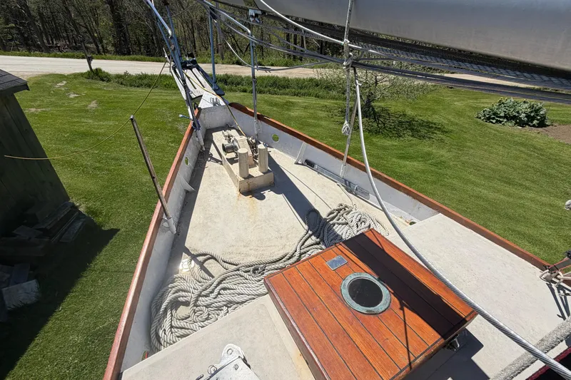 Slide: The Image of 1991 Hylan Offshore Steel Cutter deck with ropes and wooden hatch, surrounded by greenery. - 25