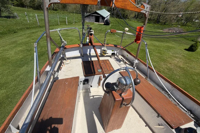 Slide: The Image of 1991 Hylan Offshore Steel Cutter sailboat deck with wooden benches and steering wheel. - 28