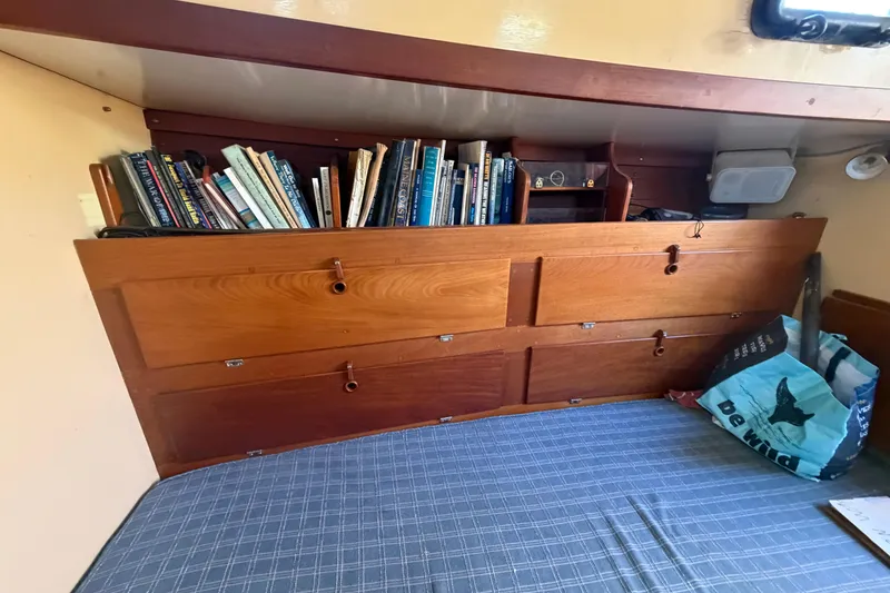 Slide: The Image of Cozy cabin interior of 1991 Hylan Offshore Steel Cutter with books and wooden storage. - 9