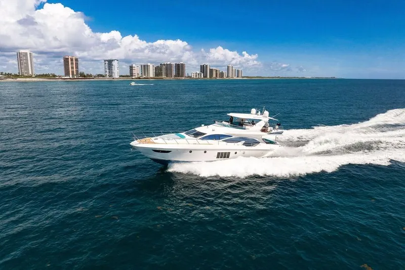 Slide: The Image of Luxurious 2011 Azimut 70 yacht cruising near coastal city skyline under clear blue skies. - 128