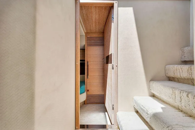 Slide: The Image of Interior view of a 2011 Azimut 70 yacht, featuring a narrow hallway and staircase. - 72