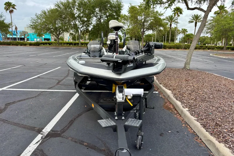 Slide: The Image of 2006 Champion 198 Elite boat on trailer in parking lot, surrounded by trees. - 1