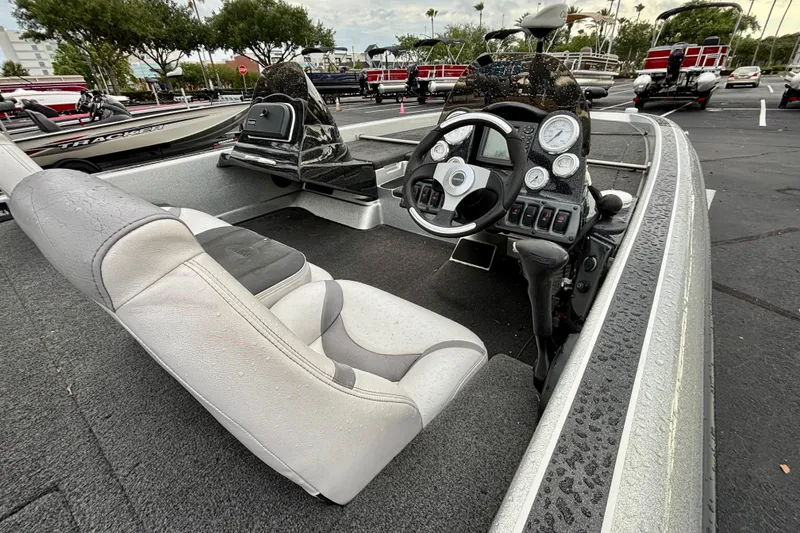 Slide: The Image of 2006 Champion 198 Elite boat interior with steering wheel and gauges, parked outdoors. - 11