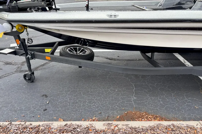 Slide: The Image of 2006 Champion 198 Elite boat on trailer, parked on asphalt surface. - 2