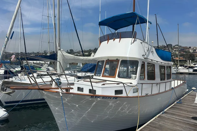The Image of 1973 CHB 33 boat docked at marina, featuring classic design and blue canopy. - 1