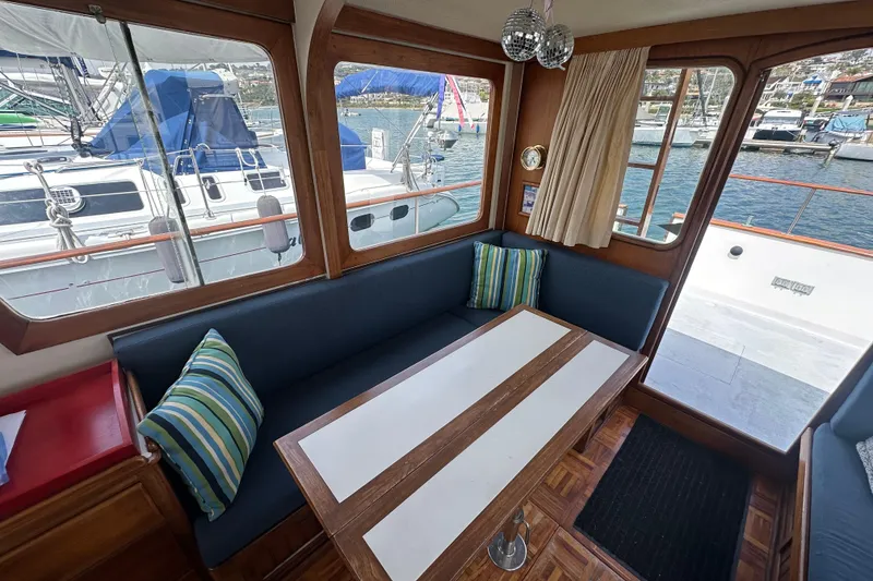Slide: The Image of Interior of a 1973 CHB 33 boat with seating, table, and marina view. - 13