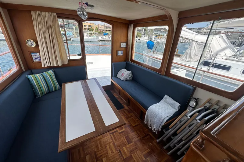 Slide: The Image of Interior of a 1973 CHB 33 boat with cozy seating and marina view. - 14