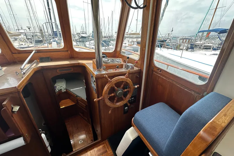 Slide: The Image of Interior of a 1973 CHB 33 boat with wooden helm and marina view. - 16