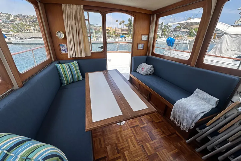 Slide: The Image of Interior of a 1973 CHB 33 boat with blue seating and wooden table. - 21
