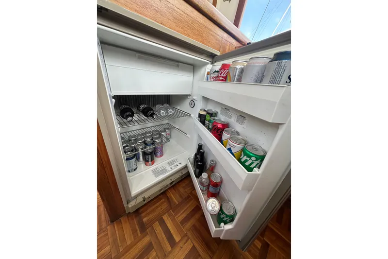 Slide: The Image of Open refrigerator stocked with various beverage cans and bottles on a CHB 33, 1973 model. - 23