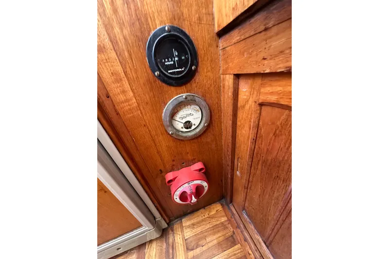 Slide: The Image of 1973 CHB 33 boat interior with gauges and a red switch on wooden panel. - 24
