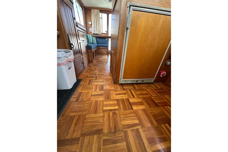 Slide: The Image of Interior of a 1973 CHB 33 boat with wooden flooring and seating area. - 25