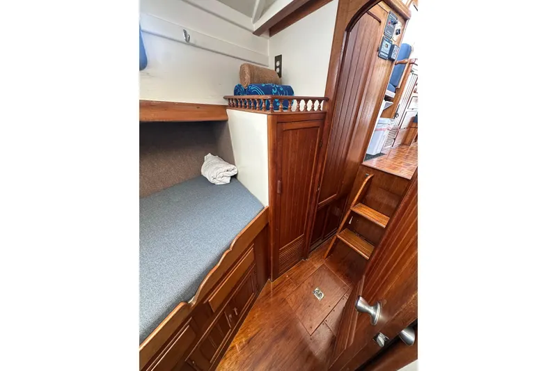 Slide: The Image of 1973 CHB 33 boat interior with wooden cabinetry, bunk bed, and stairs. - 29