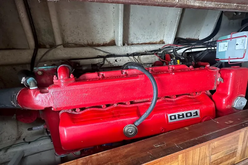 Slide: The Image of Red Ford engine inside a 1973 CHB 33 boat, showcasing mechanical components. - 32