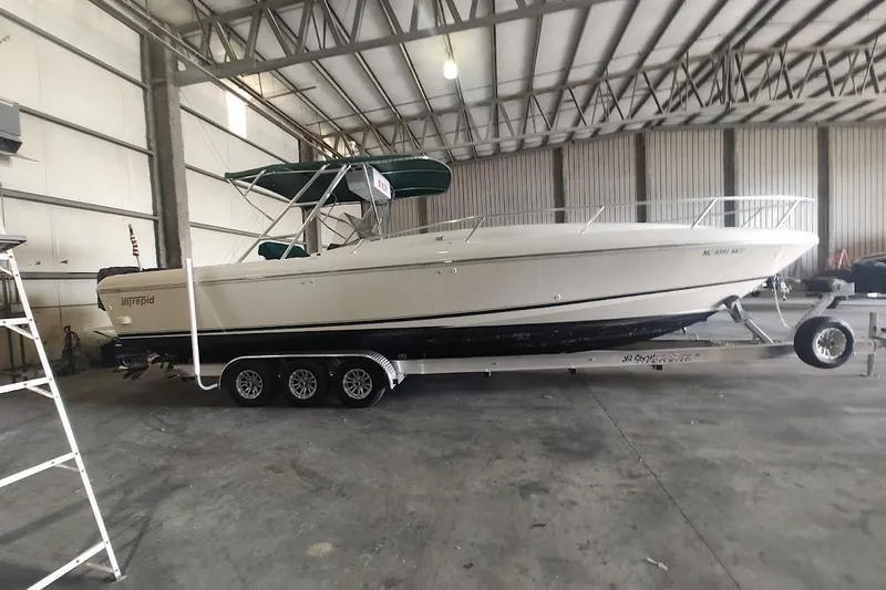 Slide: The Image of 1994 Intrepid 322 Cuddy boat on trailer in indoor storage facility. - 3