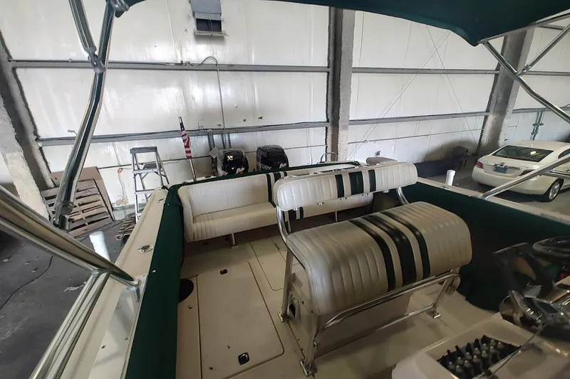 Slide: The Image of 1994 Intrepid 322 Cuddy boat interior with striped seating in a garage setting. - 11