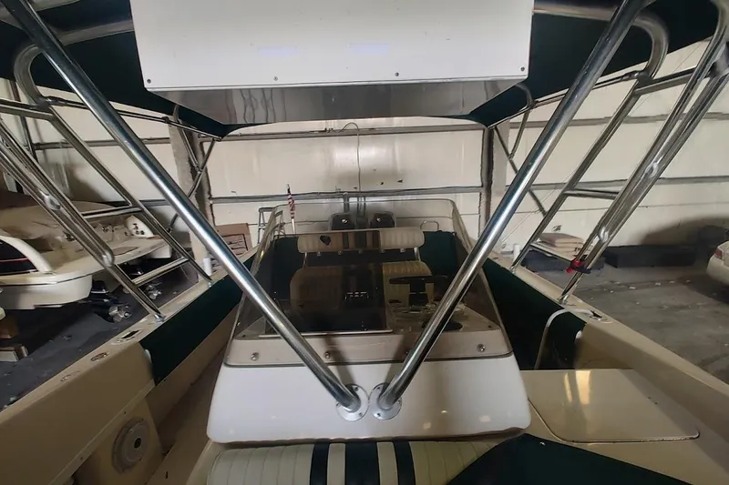 Slide: The Image of 1994 Intrepid 322 Cuddy boat interior with steering console and seating in storage. - 12