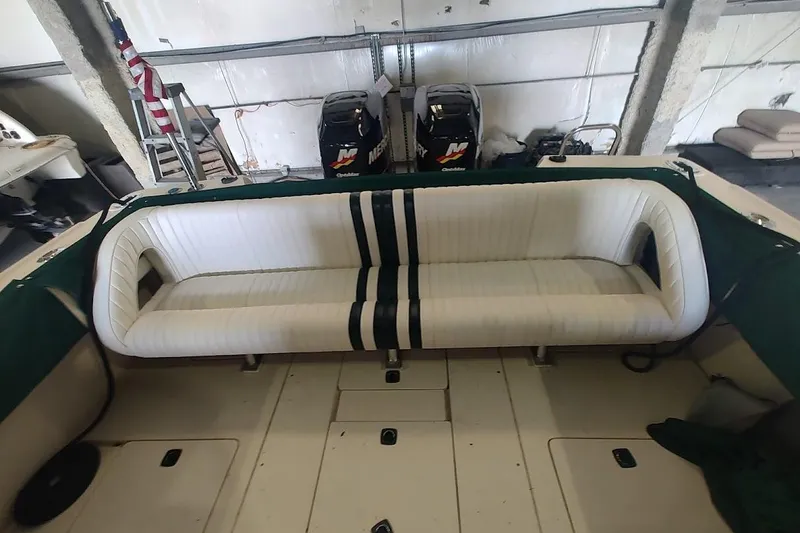 Slide: The Image of 1994 Intrepid 322 Cuddy boat interior with white cushioned seating and green accents. - 19