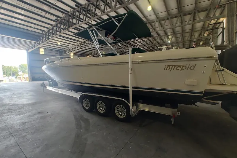 Slide: The Image of 1994 Intrepid 322 Cuddy boat on trailer inside a spacious warehouse. - 4
