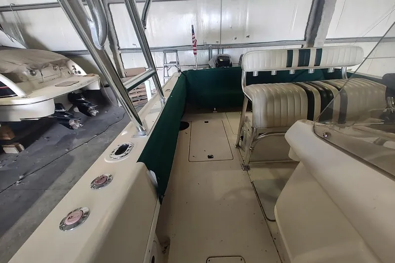 Slide: The Image of 1994 Intrepid 322 Cuddy boat interior with seating and green trim in a garage setting. - 20