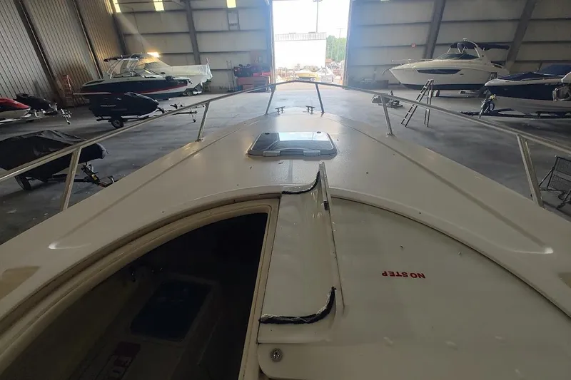 Slide: The Image of 1994 Intrepid 322 Cuddy boat in storage, showcasing deck and surrounding vessels. - 21