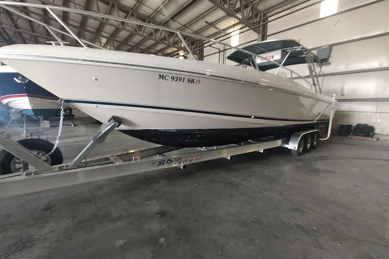 Slide: The Image of 1994 Intrepid 322 Cuddy boat on trailer in indoor storage facility. - 2