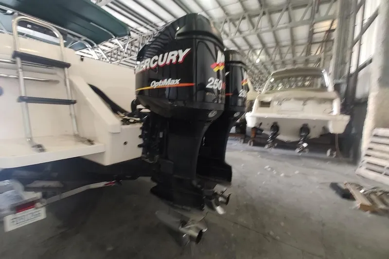 Slide: The Image of 1994 Intrepid 322 Cuddy with Mercury OptiMax engines in a boat storage facility. - 6