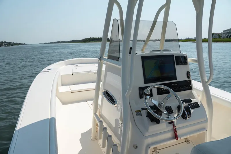 Slide: The Image of 2024 Pathfinder 2700 Open boat interior with steering console on calm water. - 18